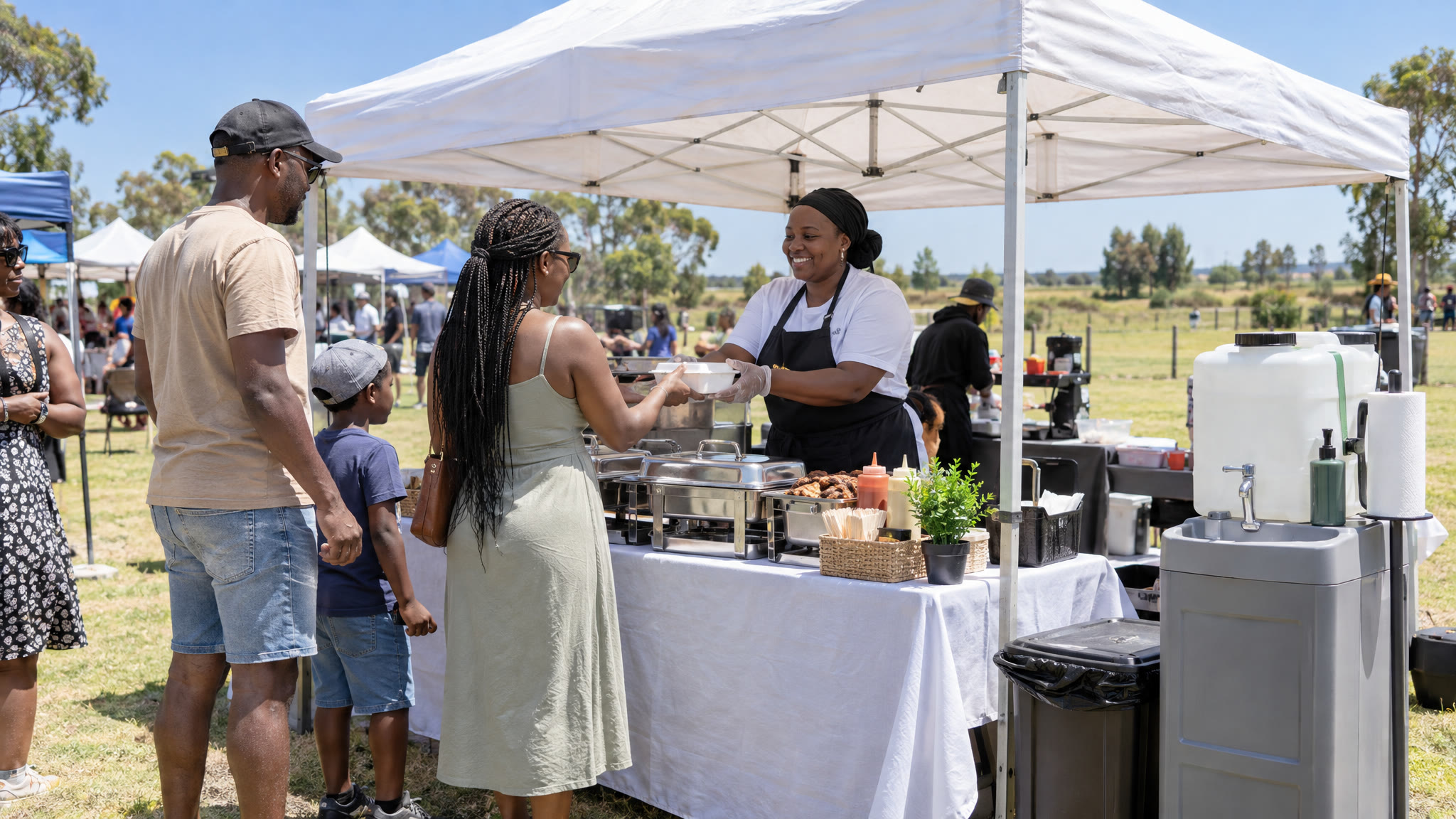 A gazebo food stall with a hand-wash station at an outdoor Highveld market