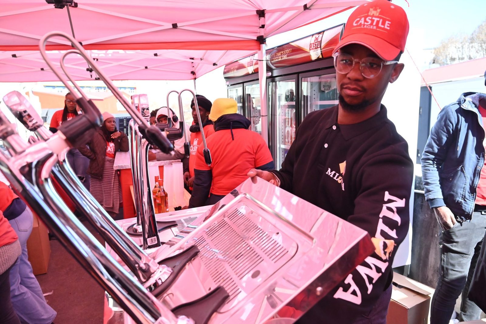 Draught beer being poured at a mobile bar under a gazebo